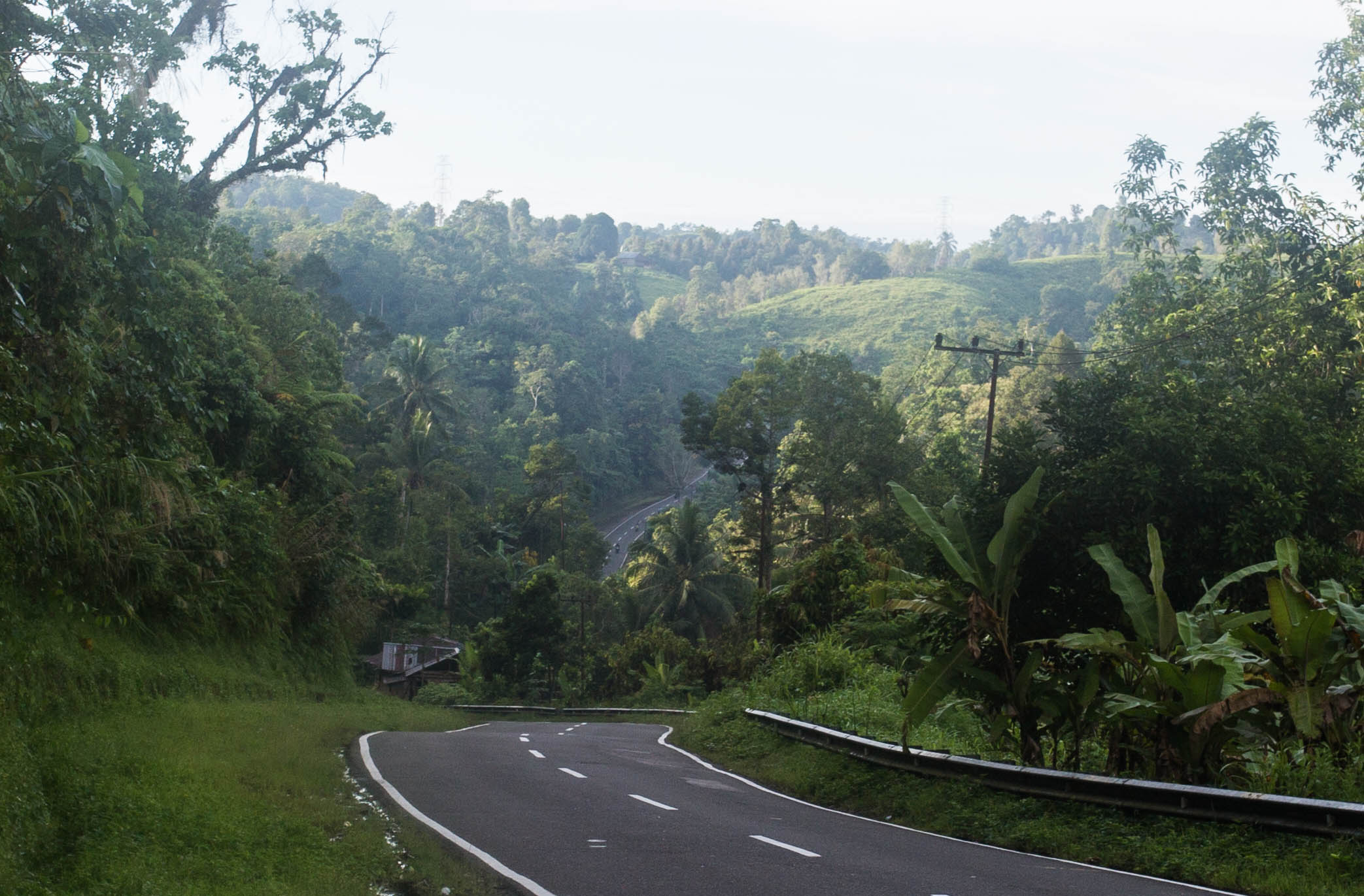 Climbing away from the Sulawesi coastline briefly, over a steep, jungle-covered headland