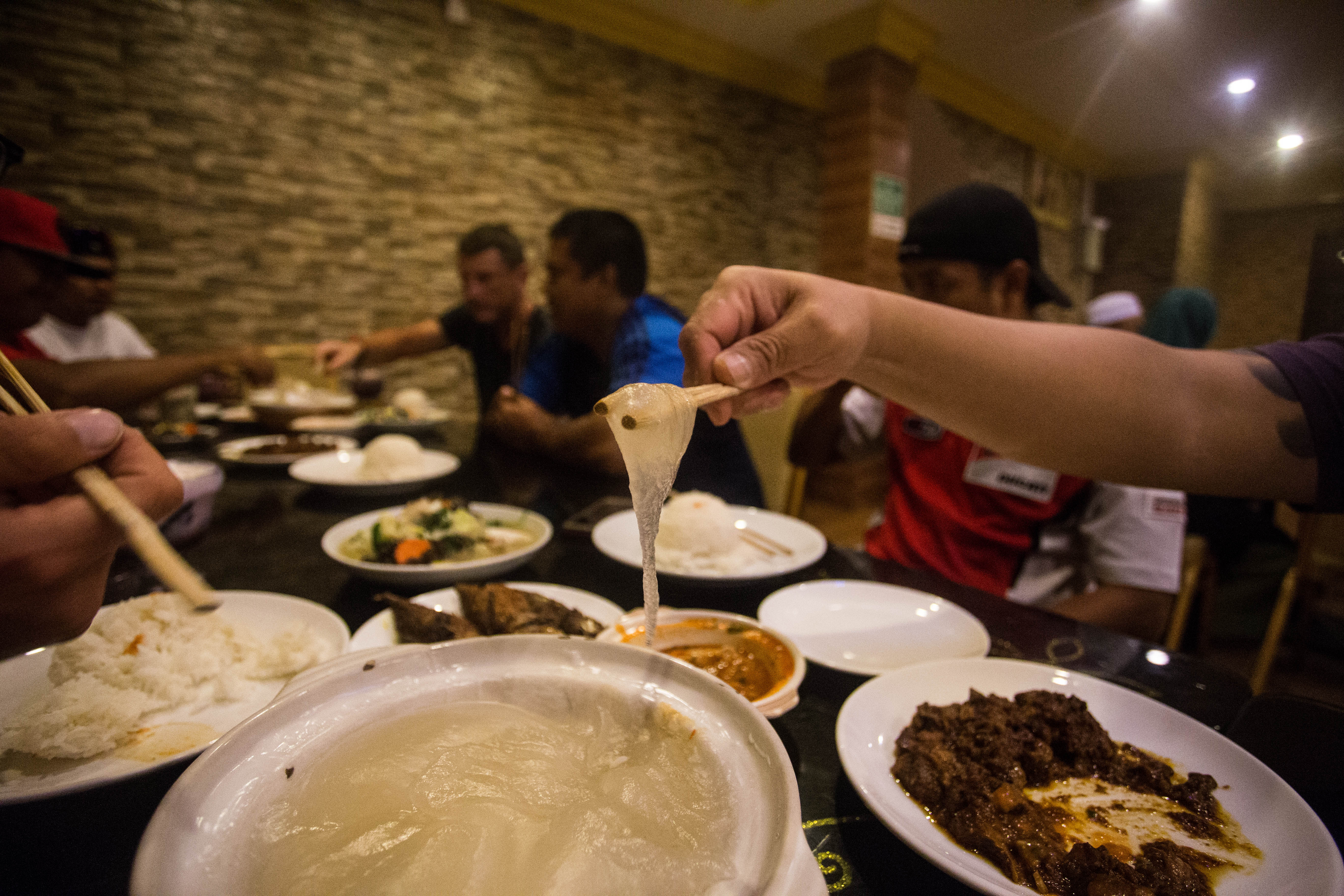 Trying sago paste, made from the extract of palm stems, a dish unique to Borneo