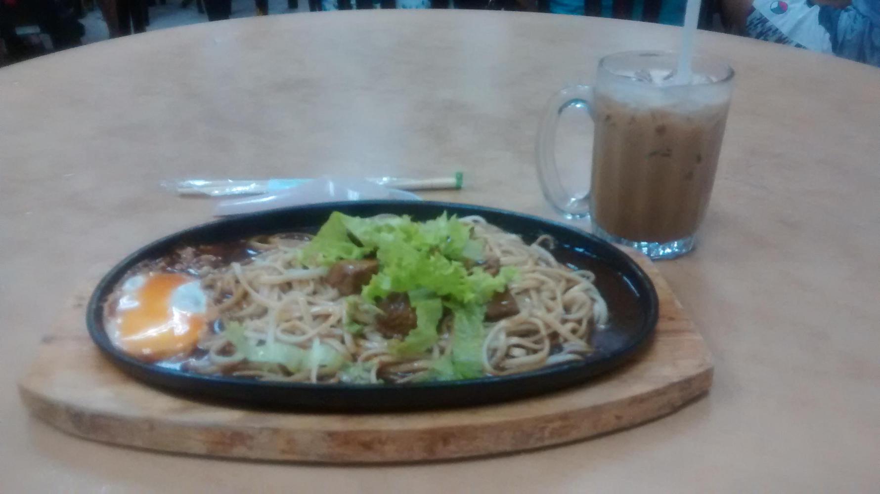 Enjoying a Sizzling Yee Mee with a thick iced coffee. The food in Malaysia (and Thailand) had blown me away