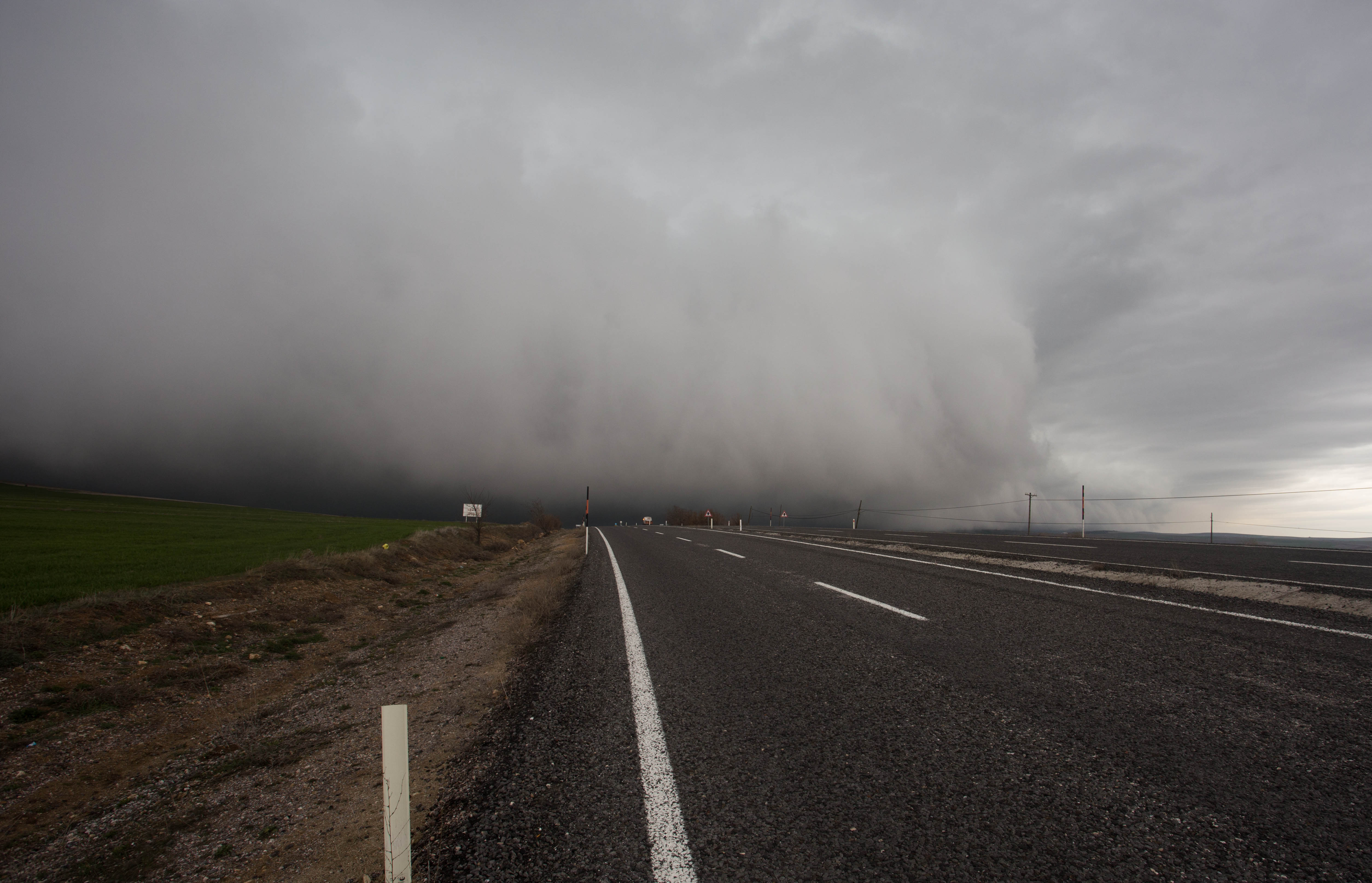 Looking behind me as an immense wall of dark cloud chases me down near the summit of my last pass before Cappadocia