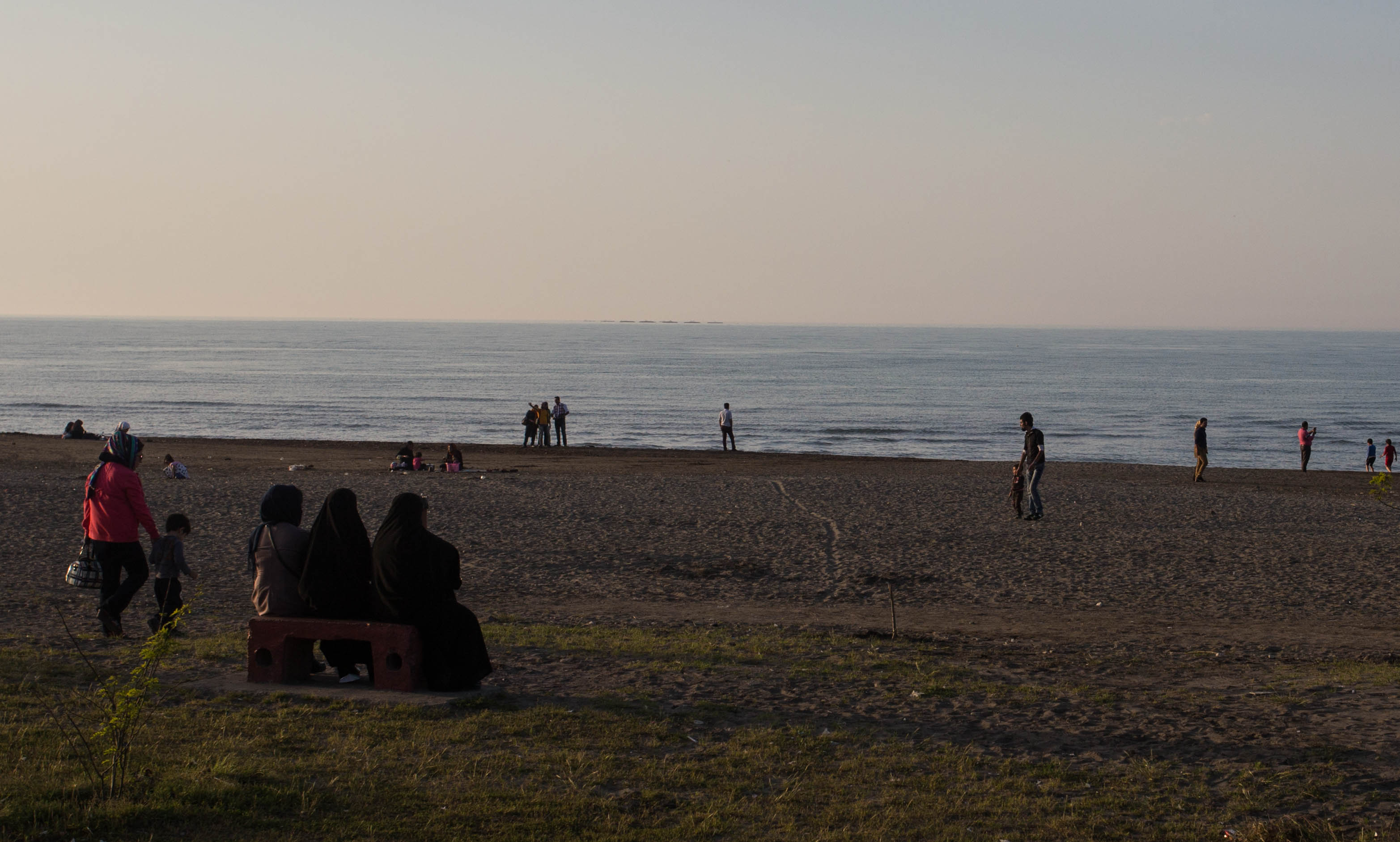 Three women in chadors overlooking the Caspian Sea