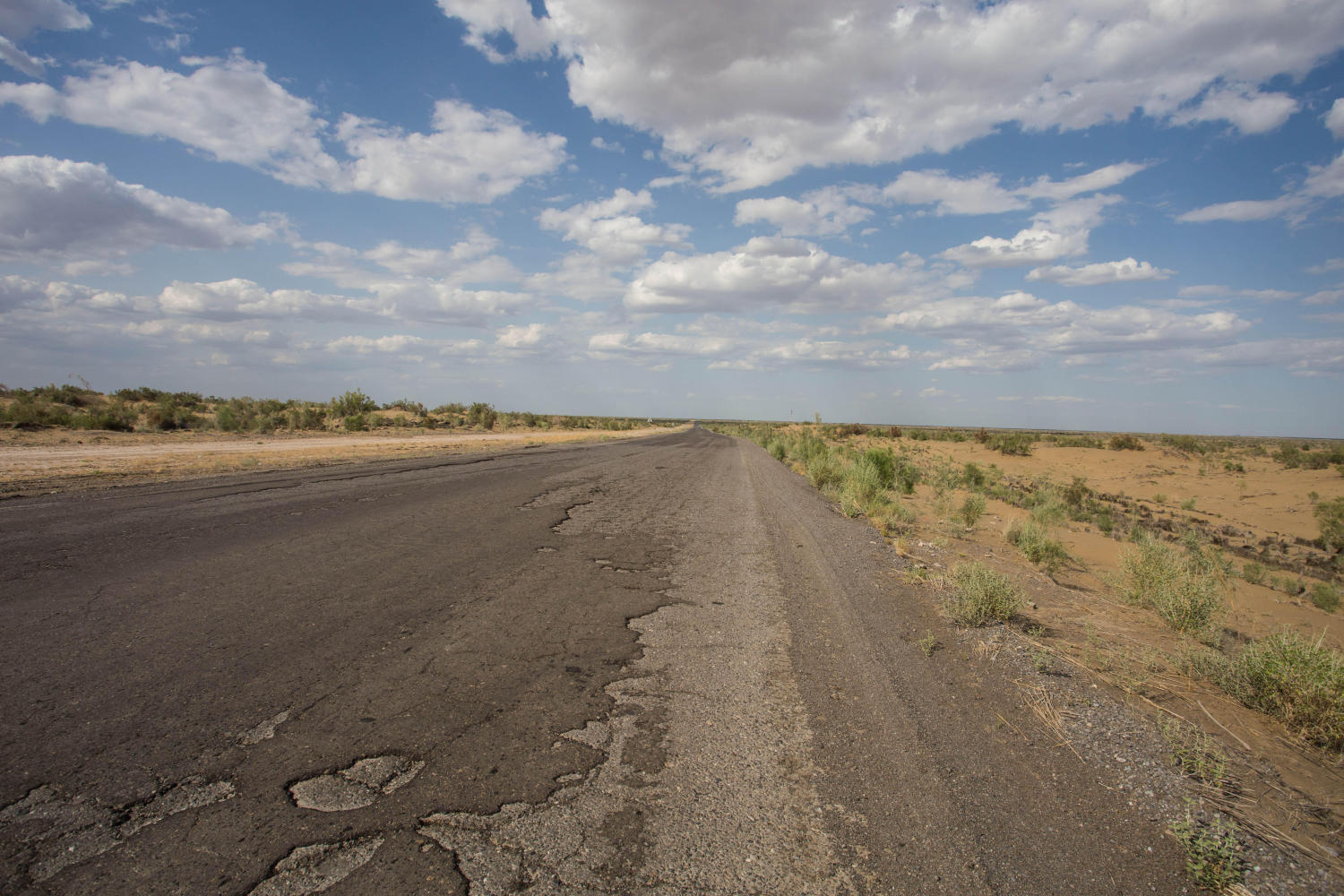The broken tarmac road traversing the Karakum Desert