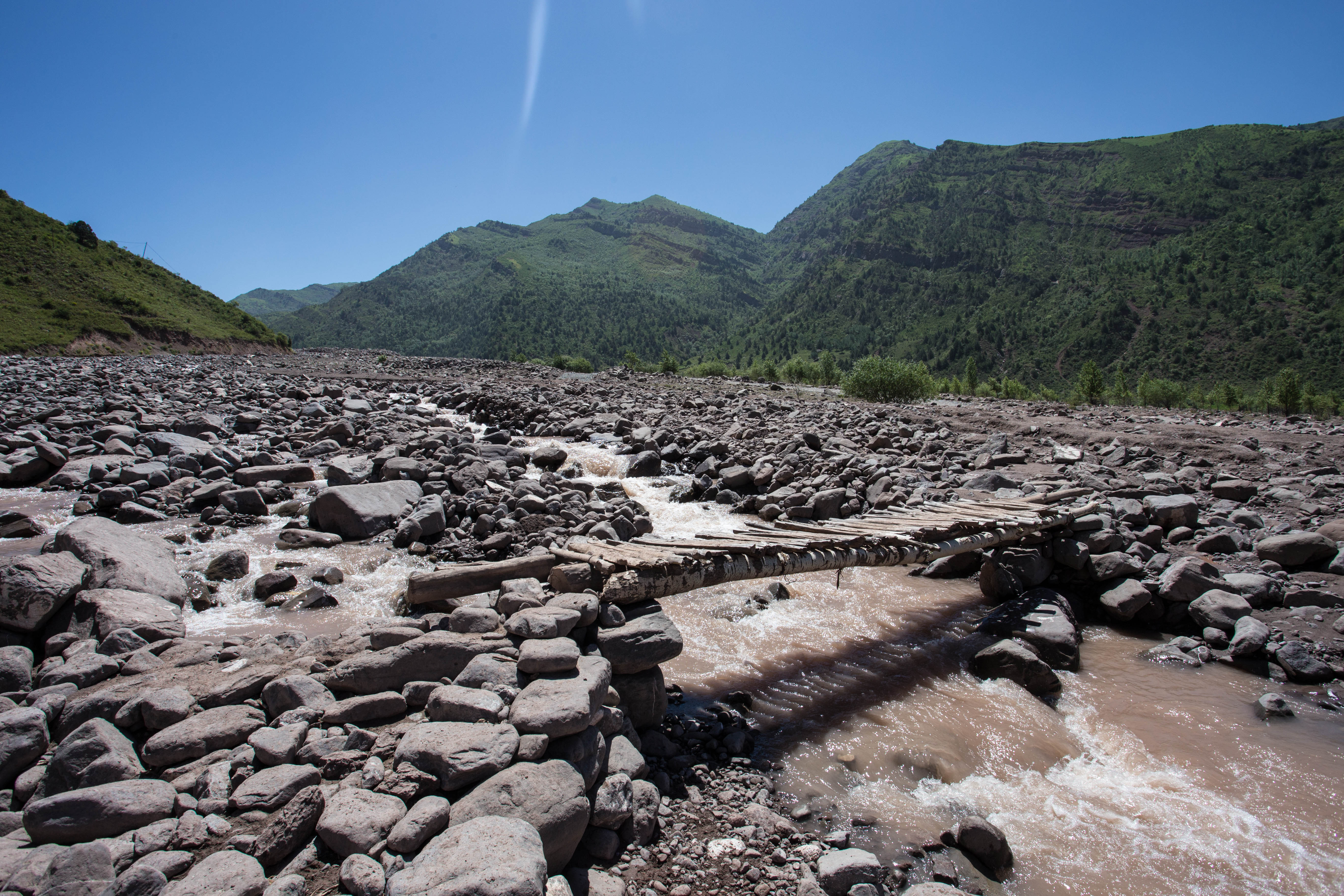 The river had washed away the road here, meaning I had to push my bicycle across this sketchy bridge