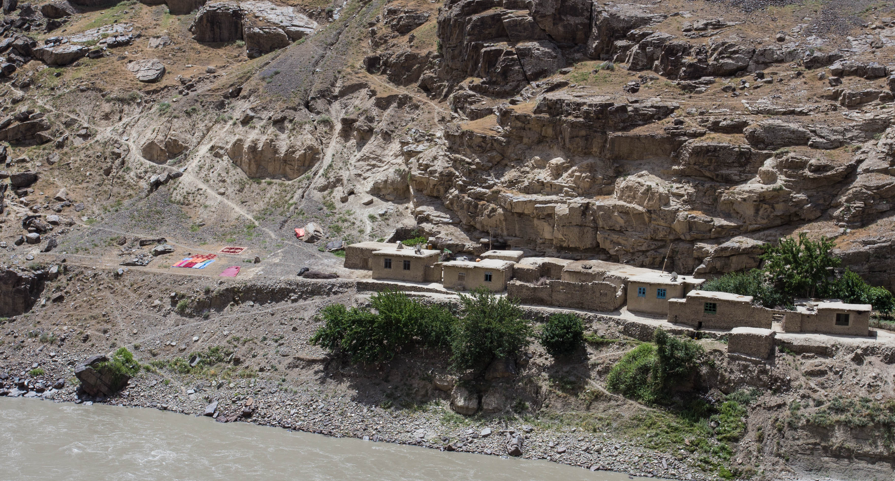 Some Afghan houses on the far bank, with their carpets drying nearby in the sun
