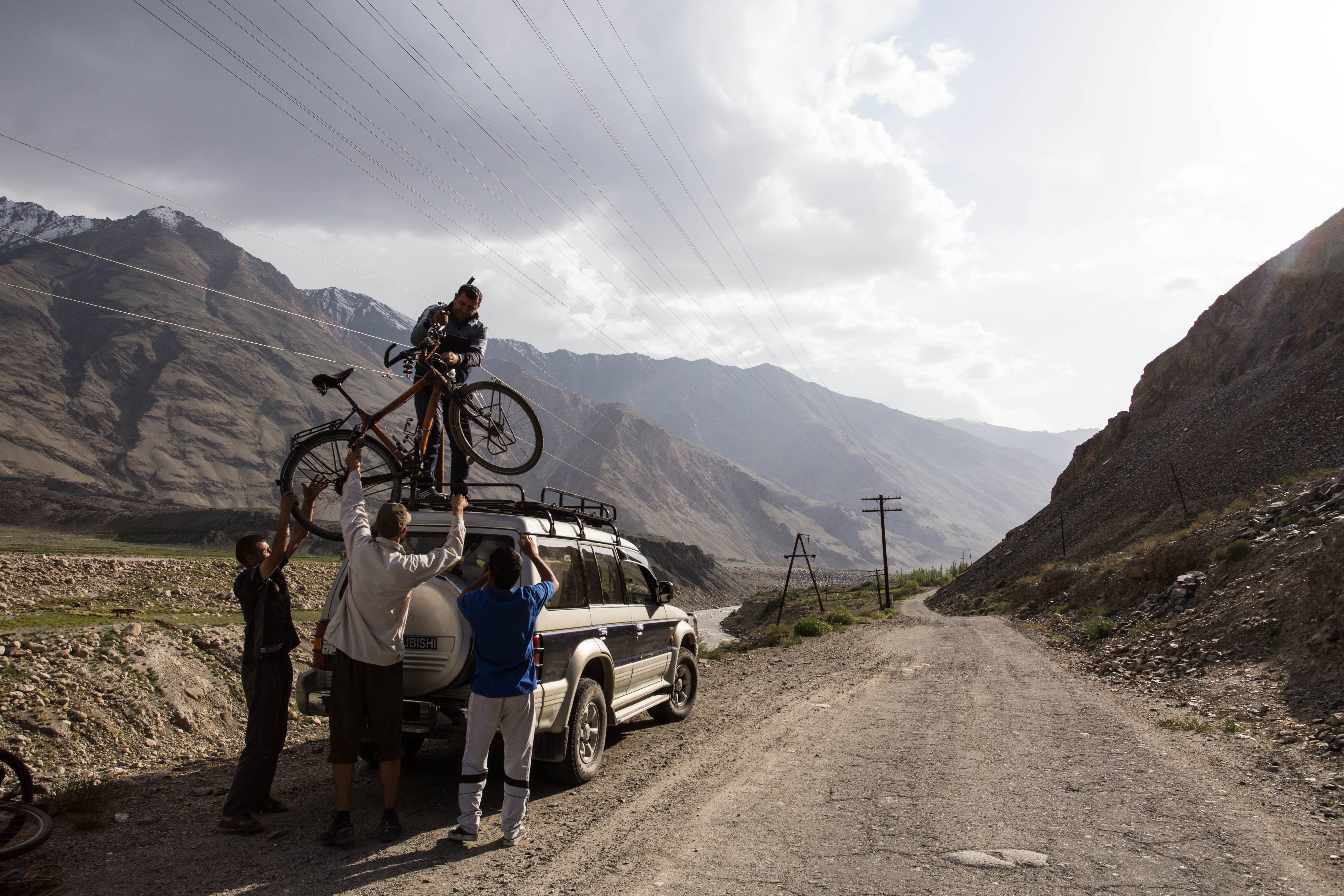Tim loading his bamboo bicycle onto a jeep, just before him and Karina were whisked off back to Khorog