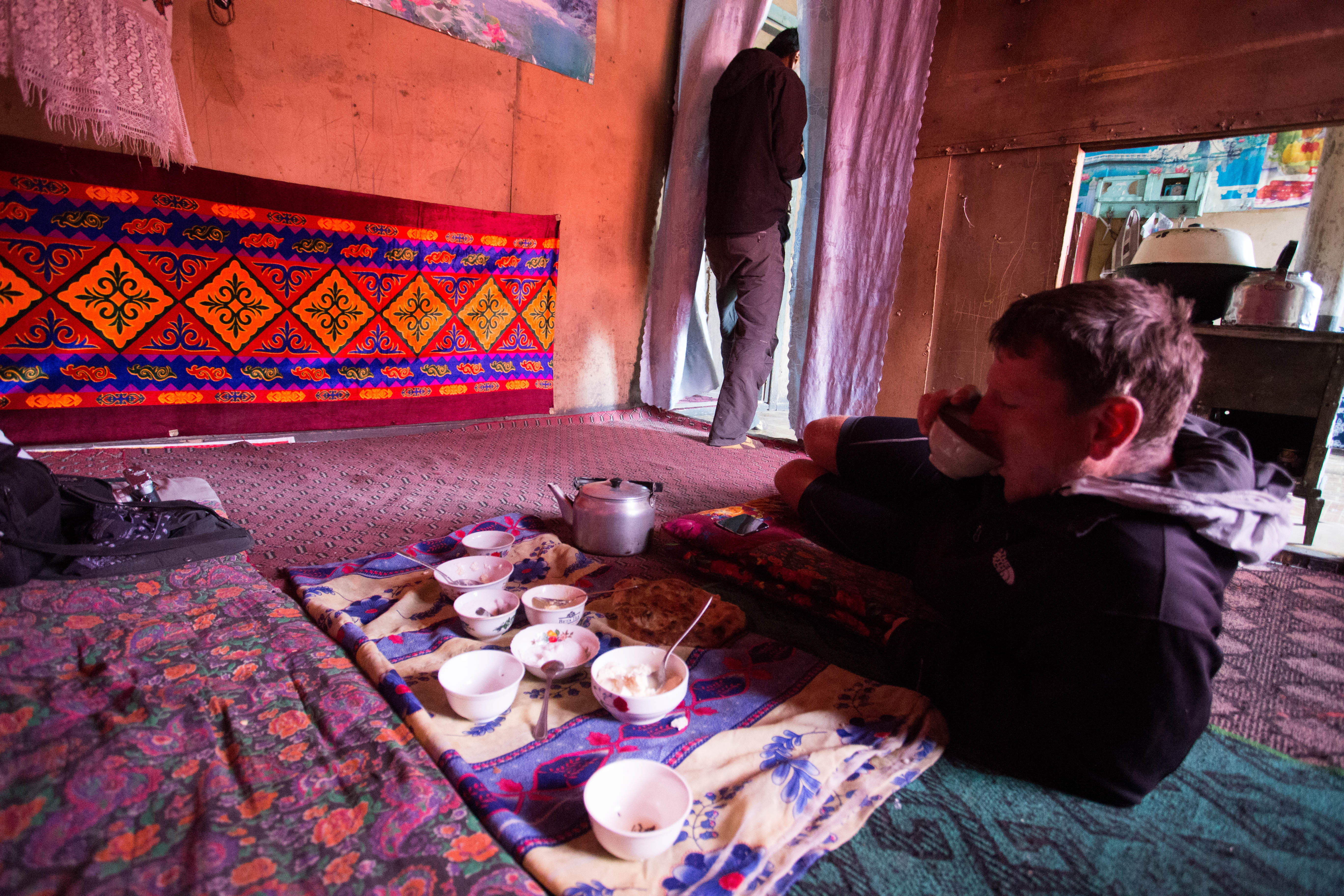 Matthew drinking some hot tea in the family home near the summit of the Ak-Baital Pass while we waited for the storm to pass