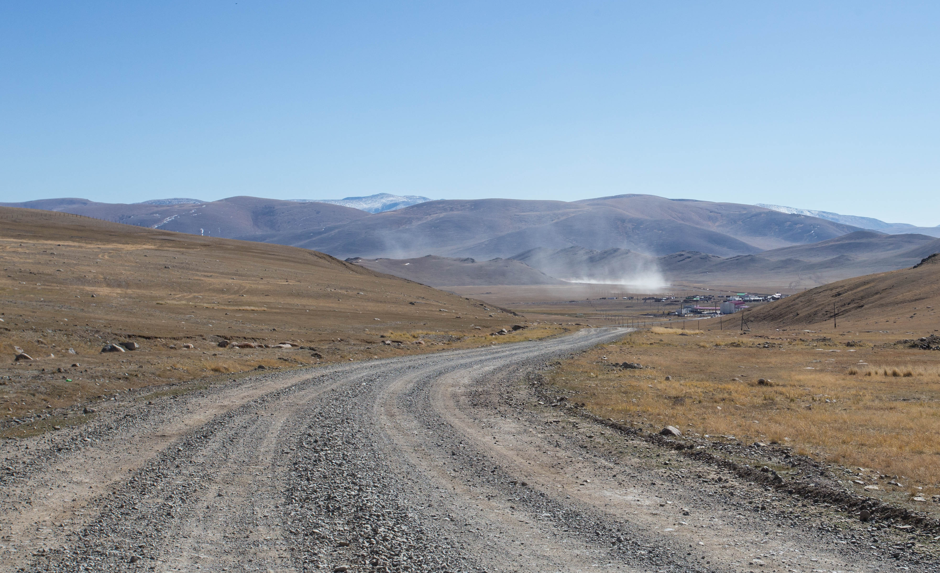 Descending a rough gravel track out of no man's land to the Mongolian border post
